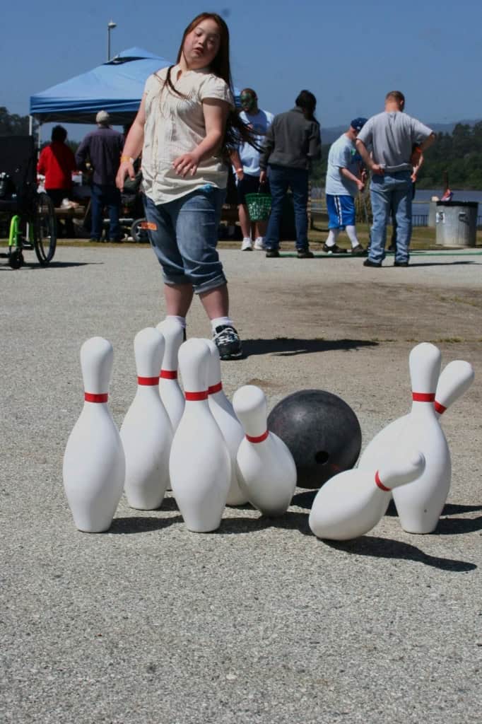 Bowling Young woman bowling at a picnic