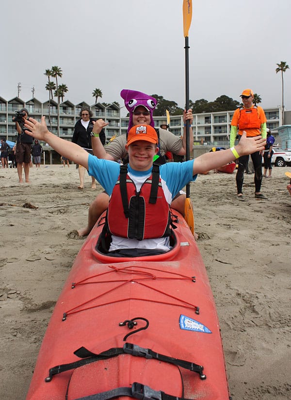 donate-day-on-the-beach Volunteer helping a young man with special needs kayak at Day on the Beach