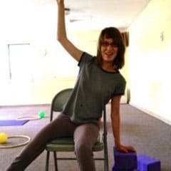 Girl with disabilities doing chair yoga