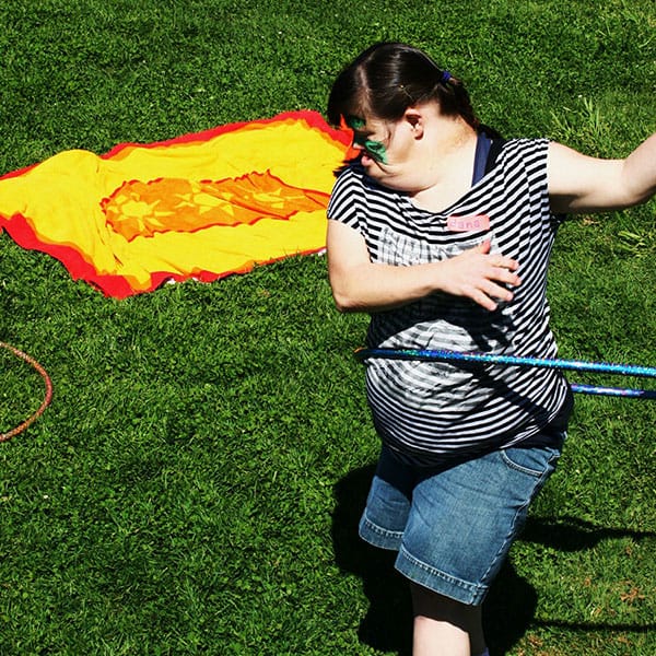 Woman with Down Syndrome hula hooping at a picnic