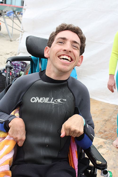 Boy with special needs floating in a beach wheelchair in the ocean