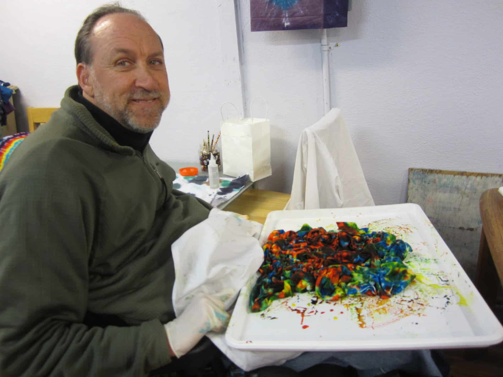 Foster tie-dying a shirt at A Brighter World